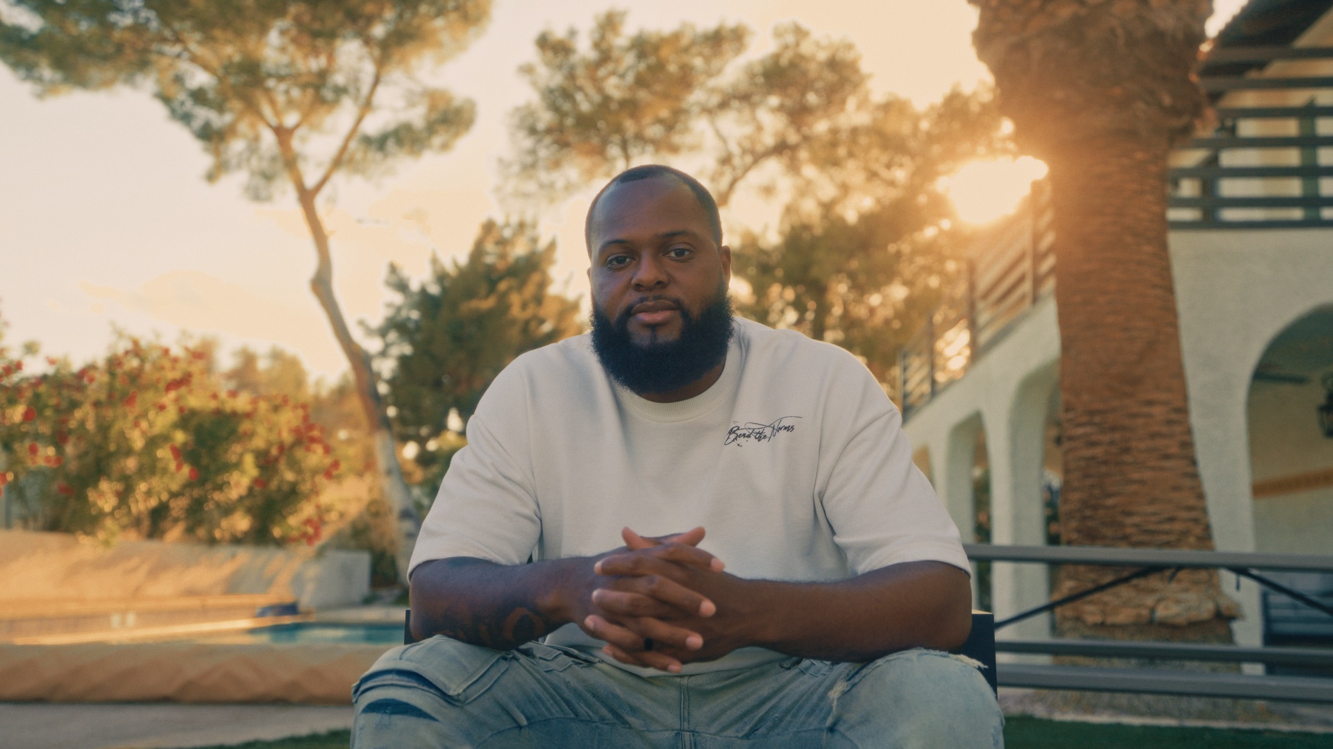Business owner seated outdoors during a filmed interview at sunset