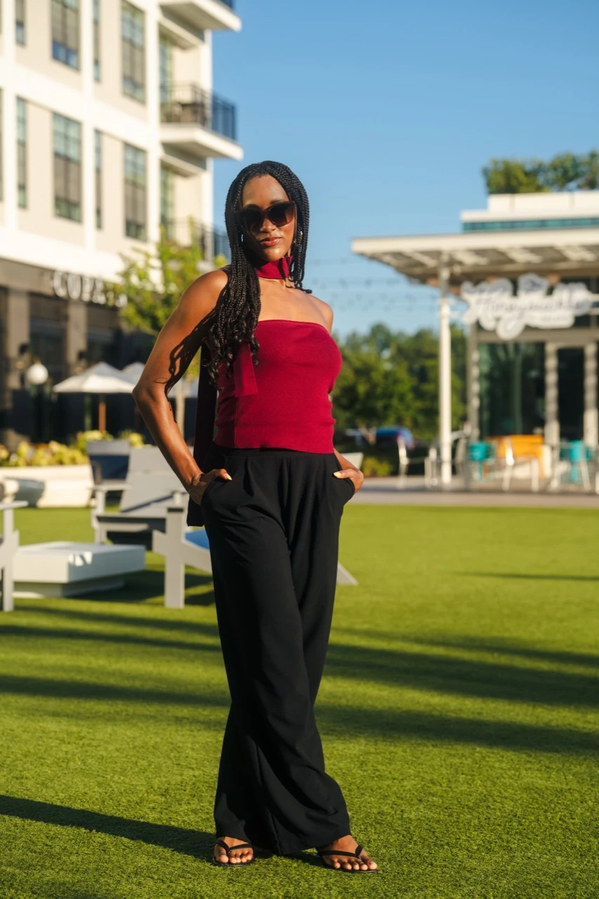 Jasmine Neely standing outdoors in a burgundy top and black trousers
